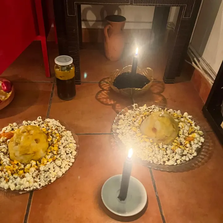 Oferendas de pipoca e velas acesas diante do altar